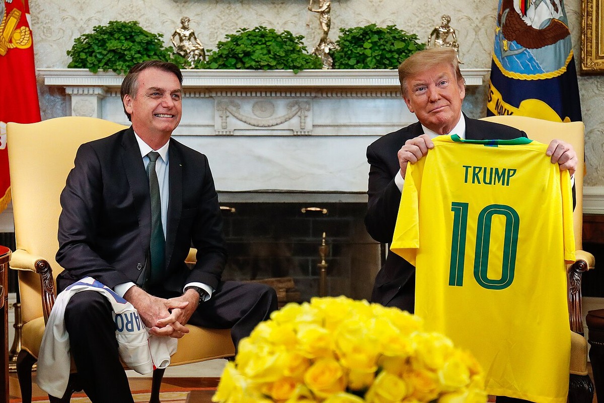 Jair Bolsonaro e Donald Trump trocam camisas de futebol no Salão Oval da Casa Branca, durante a visita oficial a Washington